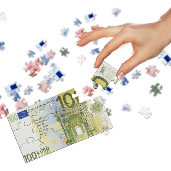 پازل اسکناس های یورو و دست هایی که جمع آوری شده است نماد تجارت