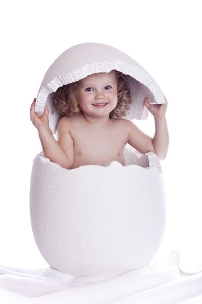 کودک در تخم مرغ در پس زمینه سفید