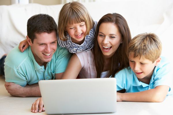 والدین جوان با فرزندان در رایانه لپ تاپ