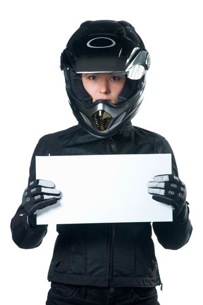 زنی با لباس موتور سیکلت سیاه و کلاه ایمنی که تخته سفیدی در دست دارد جدا شده روی سفید