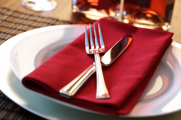 چیدمان میز شیک با چنگال چاقو و دستمال قرمز