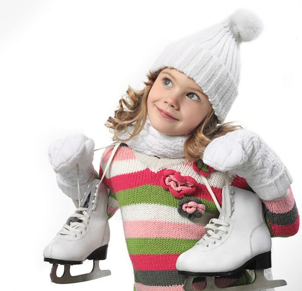 دختر کوچولوی زیبا با کلاه گرم و دستکش با اسکیت روی پس زمینه سفید
