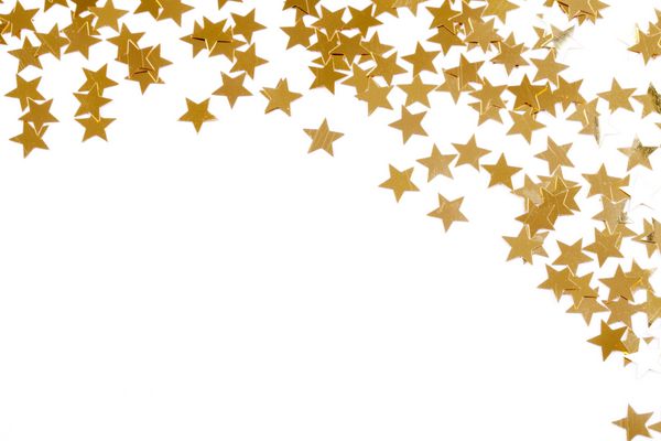 تزیین کریسمس از ستاره های طلایی کنفتی در مقابل پس زمینه سفید با بوکه زیبا
