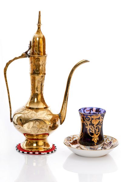 قهوه جوش عربی برنجی با یک فنجان قهوه نماد مهمان نوازی و پذیرایی از مهمان
