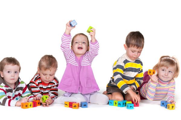 پنج کودک در حال بازی کردن بلوک های واضح با حروف هستند جدا شده بر روی پس زمینه سفید