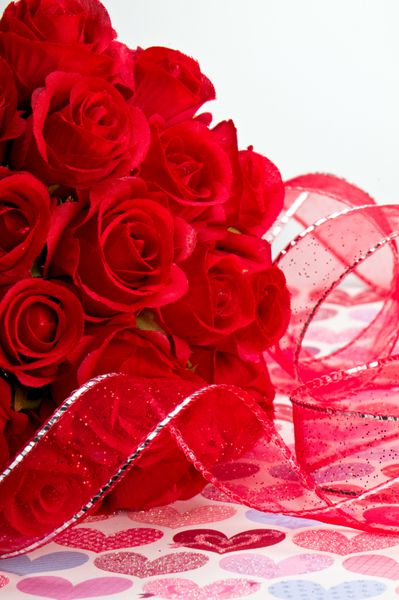 از نزدیک از گل رز قرمز و روبان قرمز برای روز ولنتاین