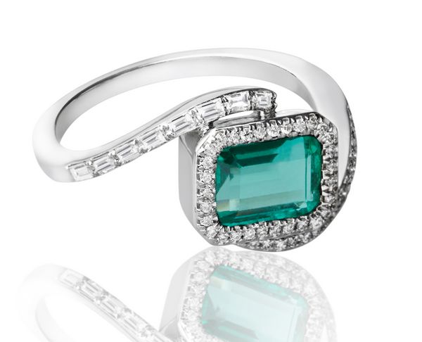 حلقه زمرد لوکس با الماس های جدا شده در زمینه سفید تزئین شده است