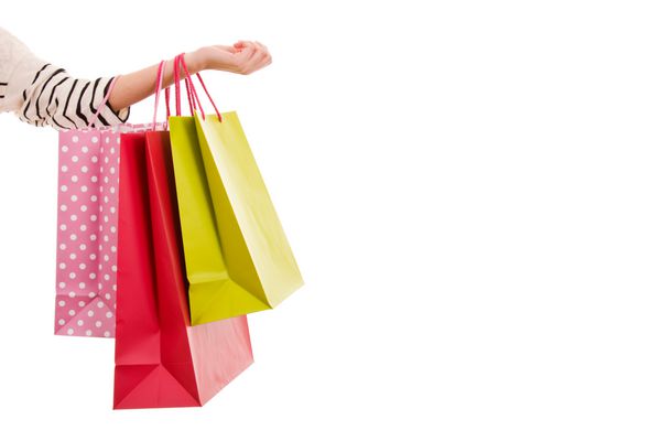 دست زن که کیسه های خرید رنگارنگ را در دست گرفته است
