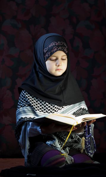 دختر مسلمان در حال خواندن قرآن