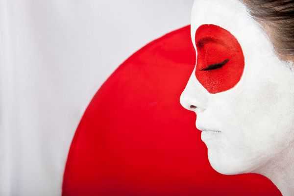 زن ژاپنی با لباس آسیایی با پرچم پشت سر