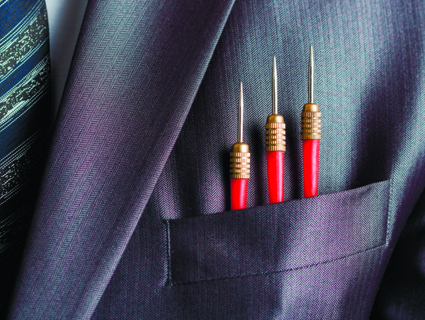 مفهوم تجاری - سه دارت قرمز در جیب کت و شلوار تاجر