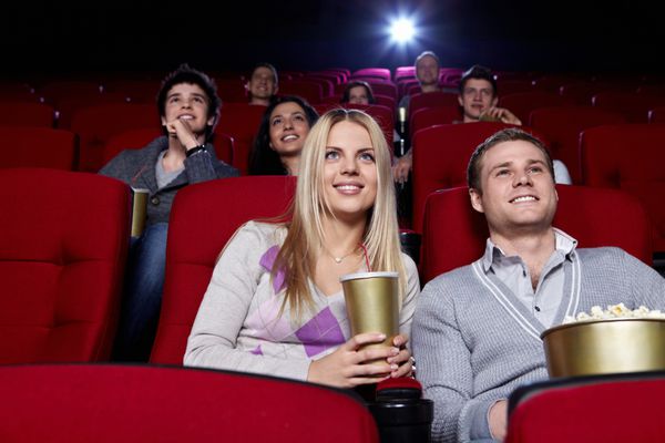 افراد جذاب در سینما در حال تماشای فیلم هستند