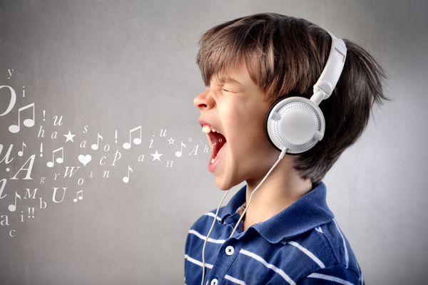 کودک هنگام گوش دادن به موسیقی با صدای بلند آواز می خواند