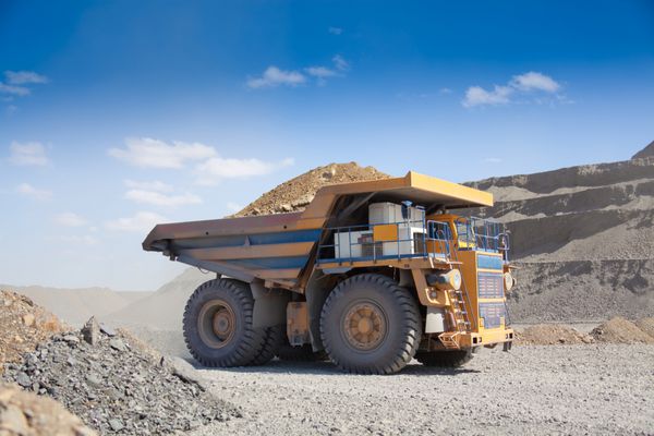 کامیون کمپرسی معدن سنگین در حال رانندگی در امتداد فضای باز