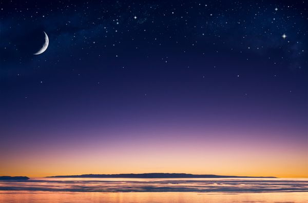 هلال ماه و ستاره بر فراز جزیره ای در اقیانوس آرام درست پس از غروب خورشید