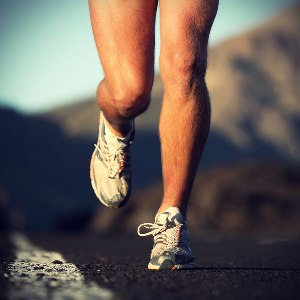 ورزش دویدن پاها و کفش های دونده مرد در حال حرکت در جاده در خارج از منزل در غروب آفتاب مدل ورزشکار مرد