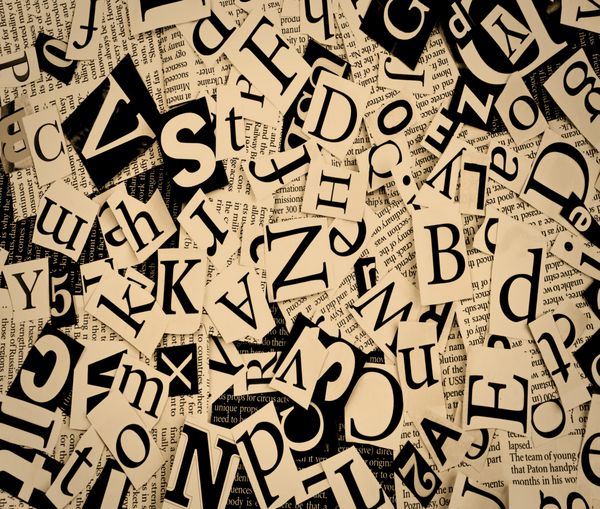 حروف بریده شده از روزنامه پس زمینه