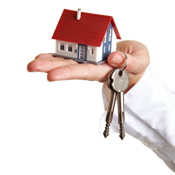 دست در دست گرفتن خانه کوچک و تعدادی کلید