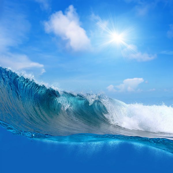 تصویر غوطه‌ور در حال موج‌سواری در اقیانوس موج‌های کف‌آلود آسمان ابری خورشید