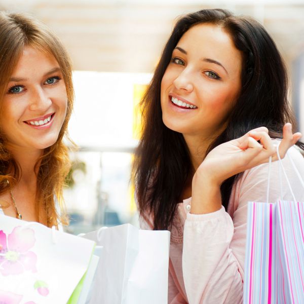 دو زن خرید هیجان زده با هم در داخل مرکز خرید شات افقی