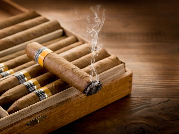 سیگار کشیدن کوبایی روی جعبه روی پس زمینه چوبی