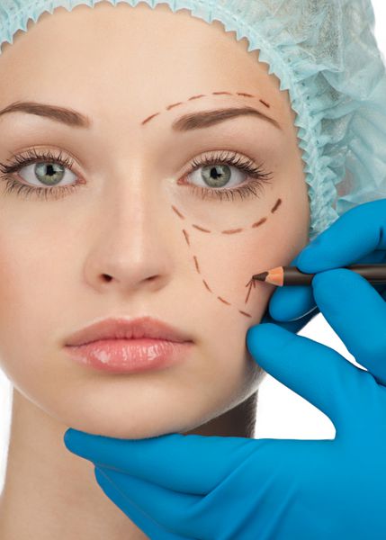 زن جوان زیبا با خطوط سوراخ روی صورتش قبل از عمل جراحی پلاستیک زیبایی چهره زن را لمس می کند