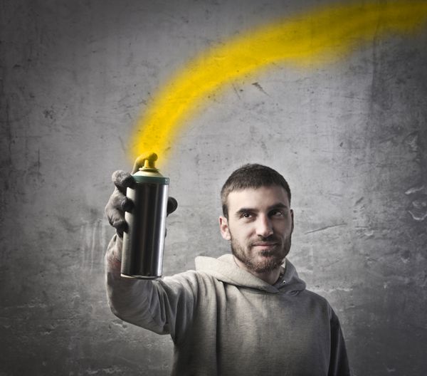 مرد جوان در حال پاشیدن رنگ زرد