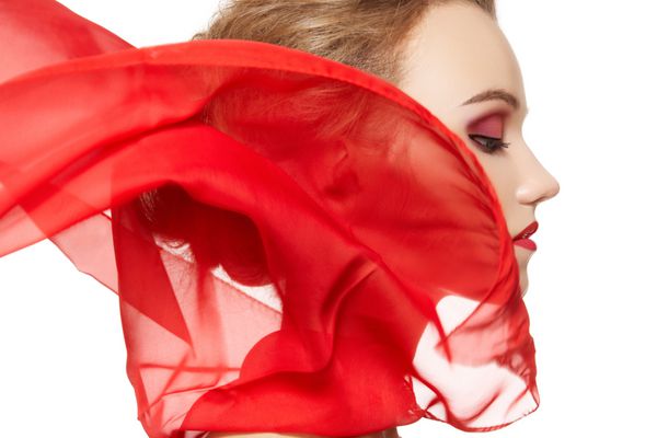 پرتره شیک یک مدل دختر با روسری ابریشمی قرمز تکان دادن مد لوازم جانبی زرق و برق آرایش شب سبک روشن آزادی vamp بانوی قرمز در پس زمینه سفید