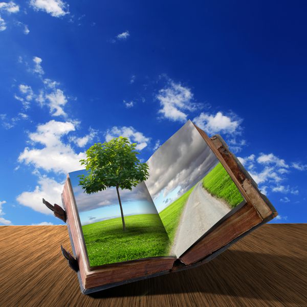 یک کتاب باز با چشم انداز طبیعی سبز در داخل