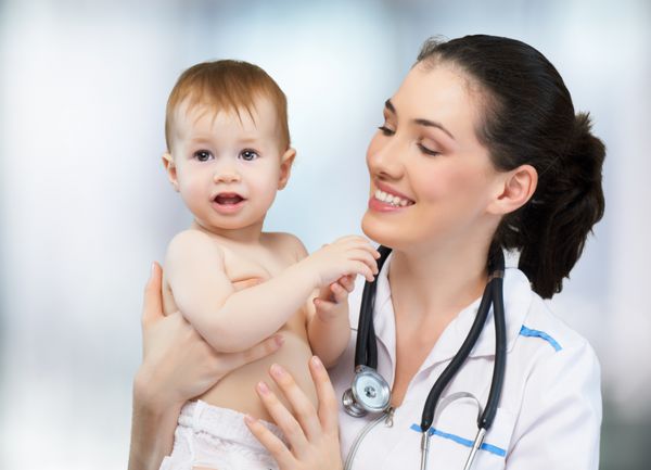 دکتری که نوزادی را روی دستانش نگه داشته است
