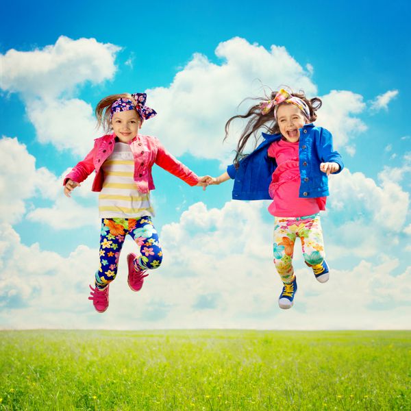 کودکان شاد و ناز در حال پریدن در زمین بهار شادی دوستی مفهوم مد روز