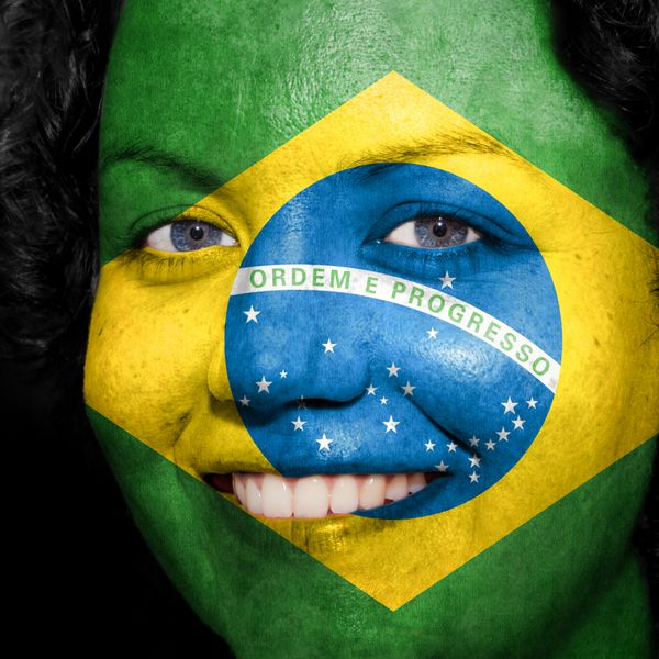 زنی با پرچم روی صورتش برای نشان دادن حمایت برزیل در ورزش
