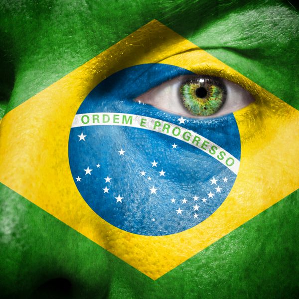 پرچم برزیل روی صورت یک مرد برای حمایت از کشورش برزیل نقاشی شده است