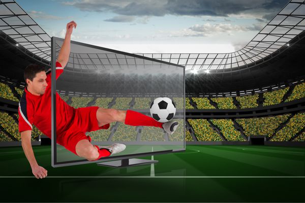 تصویر ترکیبی از فوتبالیست مناسب در حال ضربه زدن به توپ از طریق تلویزیون در مقابل استادیوم بزرگ فوتبال با طرفداران به رنگ زرد