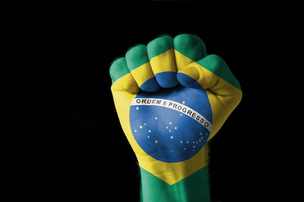 تصویر کم کلیدی از یک مشت نقاشی شده با رنگ های پرچم برزیل