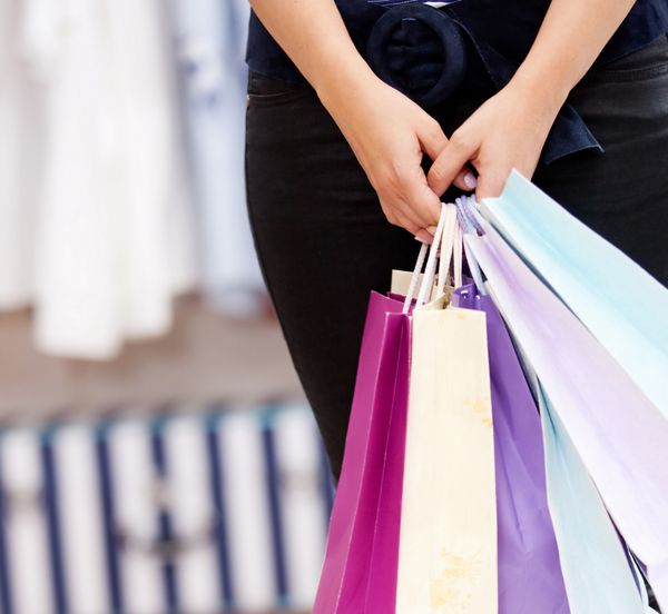 یک زن که یک کیسه خرید در یک فروشگاه در دست دارد