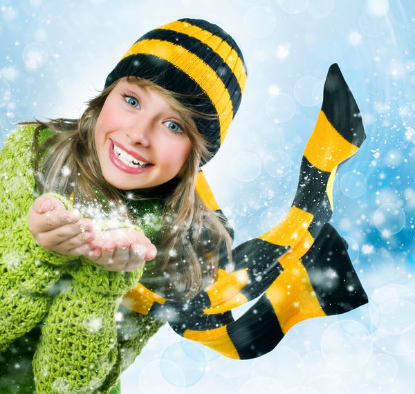 دختر کریسمس دختر نوجوان زمستانی در حال دمیدن برف