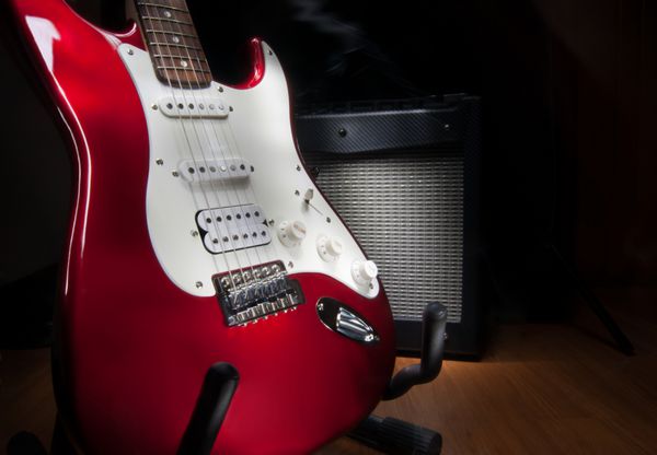 آمپلی فایر گیتار الکتریک و ترکیبی قرمز و سفید در پس زمینه مشکی