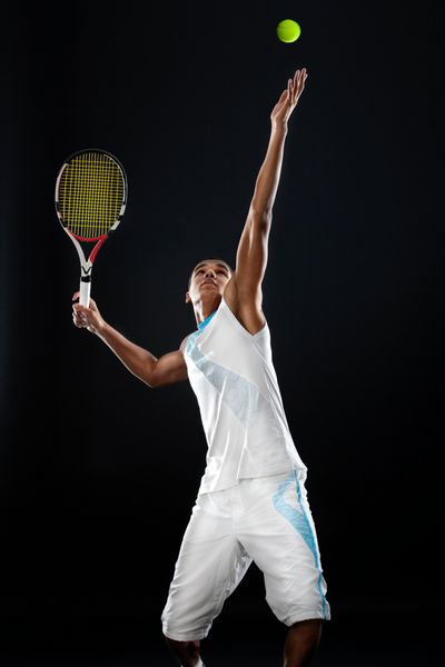 تنیسور جوان با راکت آماده سرو توپ تنیس