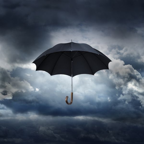 چتر سیاه قدیمی در برابر آسمان بارانی