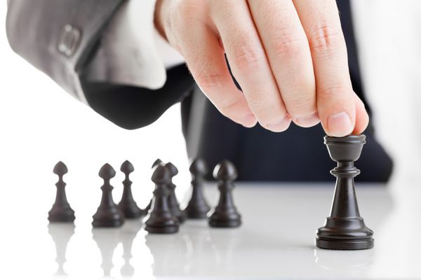 مرد تجاری در حال حرکت فیگور شطرنج با تیم پشت سر - استراتژی یا مفهوم رهبری