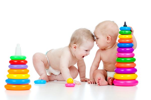 دو کودک کوچک که با اسباب بازی های رنگی بازی می کنند