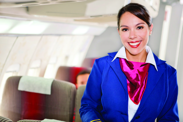 مهماندار زیبا در کابین هواپیما در حال لبخند زدن