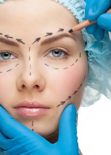زن جوان زیبا با خطوط سوراخ روی صورتش قبل از عمل جراحی پلاستیک زیبایی چهره زن را لمس می کند