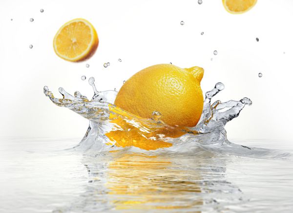 پاشیدن لیمو در آب شفاف در پس زمینه سفید