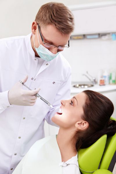 دندانپزشک در کلینیک تزریق می کند