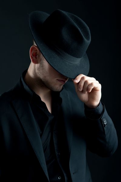 پرتره مرد جوان با کلاه در پس زمینه سیاه