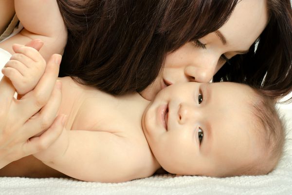 نوزاد کوچک بسیار زیبا با مادر صورت نزدیک در زمینه سفید جدا شده