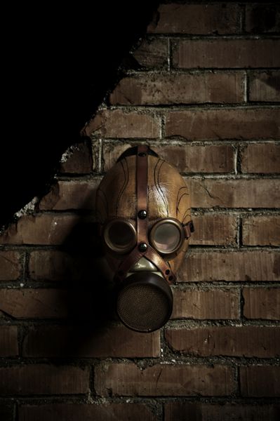 یک ماسک گاز که روی یک دیوار آجری قدیمی آویزان شده است
