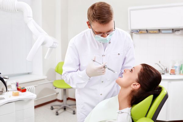 پزشک در کلینیک دندانپزشکی بیمار را تا دندان درمان می کند